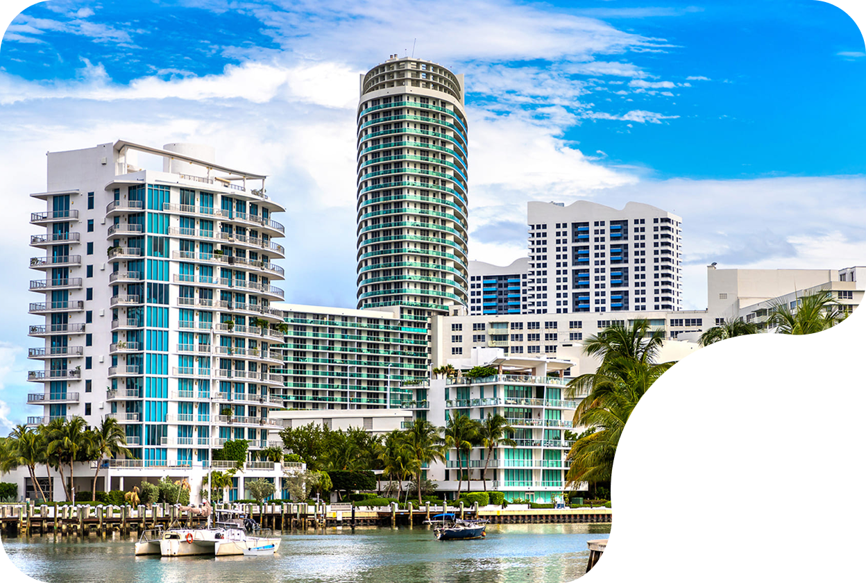 Luxury beachfront condos and high-rise apartment buildings overlooking the ocean on a sunny day
