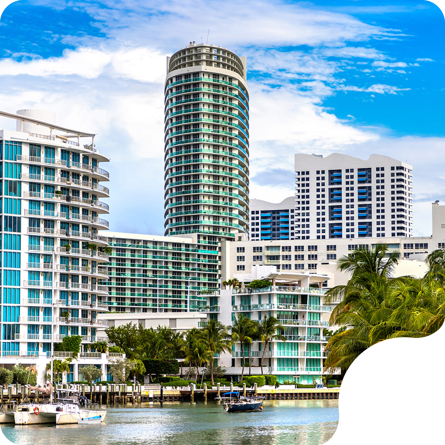 Luxury beachfront condos and high-rise apartment buildings overlooking the ocean on a sunny day