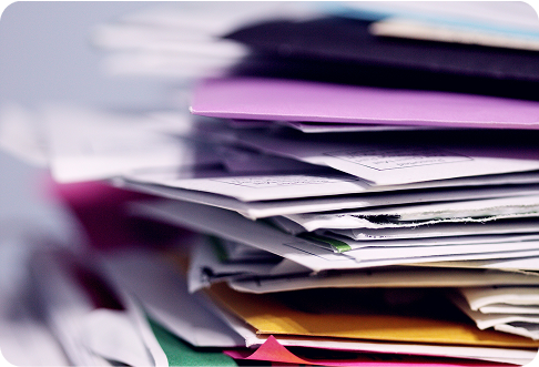 Close-up of stacked office documents and papers in colorful folders showing paperwork organization