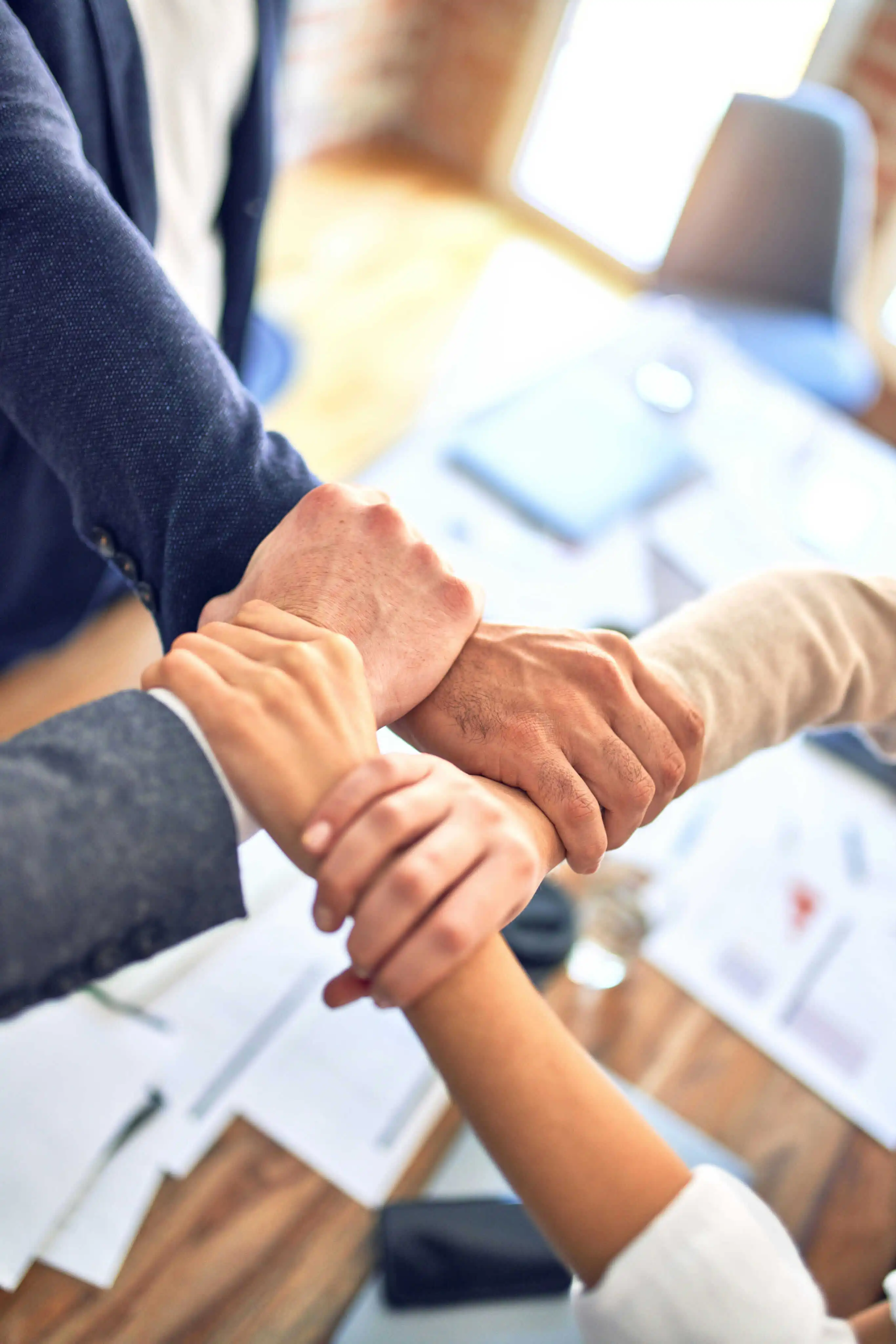Teamwork and collaboration concept with diverse business professionals joining hands in unity